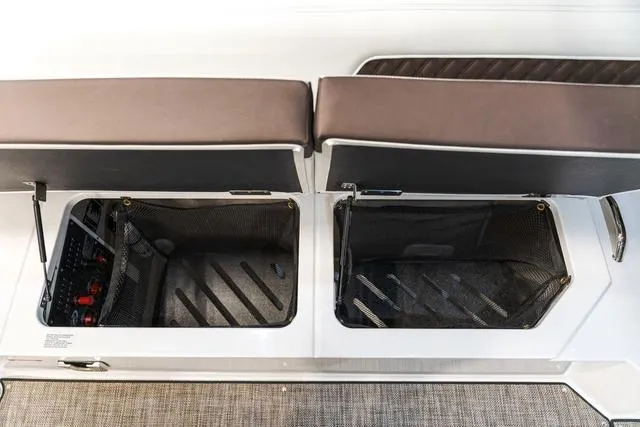 Slide: The Image of Open storage compartments on a 2025 Cobalt R33 boat with cushioned seating. - 11