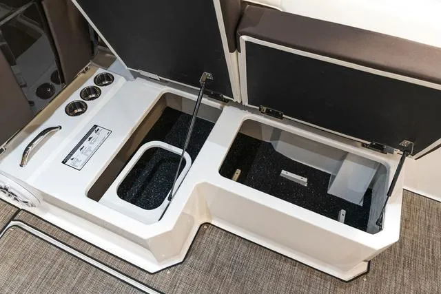 Slide: The Image of 2025 Cobalt R33 storage compartments with open lids and cup holders. - 14