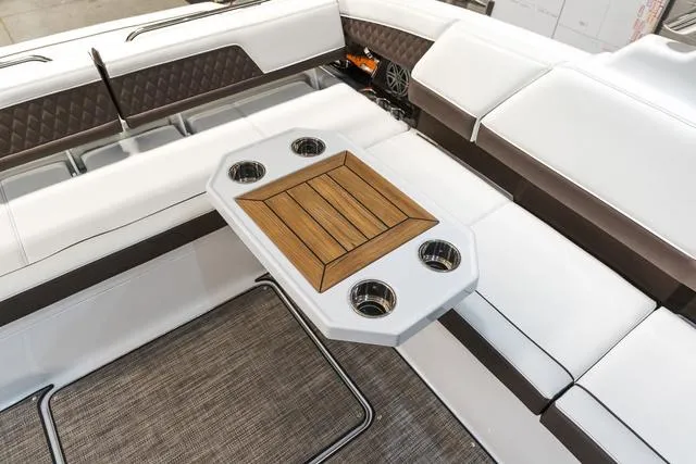 Slide: The Image of Luxury seating area in 2025 Cobalt R33 boat with wooden table and cup holders. - 18