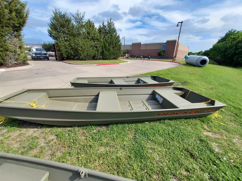 The Image of 2025 Tracker Grizzly 1436 Utility boats on grass, sunny day. - 0