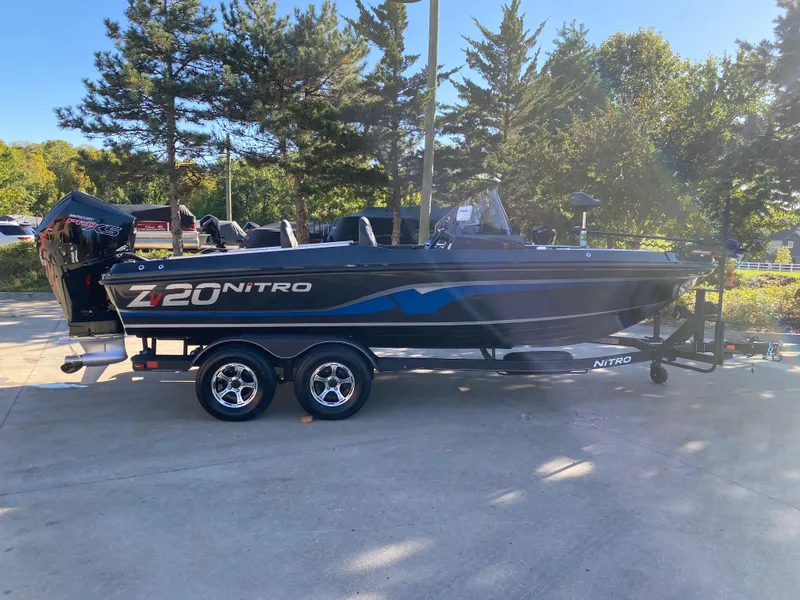 The Image of 2024 Nitro ZV20 boat on trailer, parked outdoors with trees in background. - 0
