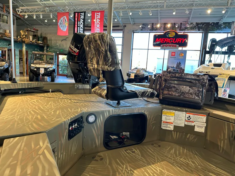 Slide: The Image of 2025 Tracker Grizzly 1654 T Sportsman boat interior with camo seats and Mercury Power signage. - 4