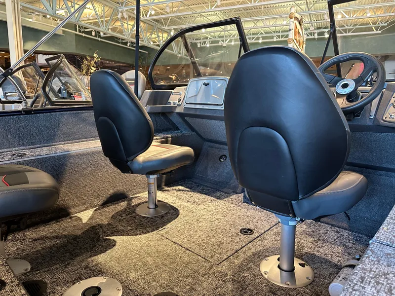 Slide: The Image of 2025 Tracker Pro Guide V-175 WT boat interior with two black seats and steering console. - 3