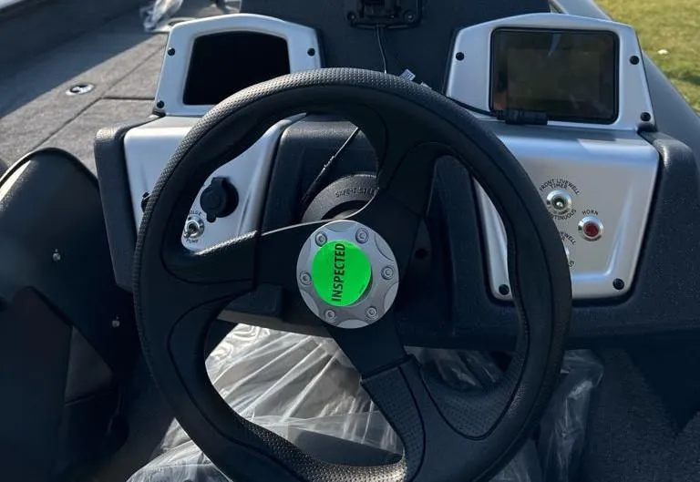 Slide: The Image of 2025 Tracker Pro Team 175 Crappie Edition boat dashboard with steering wheel and controls. - 6