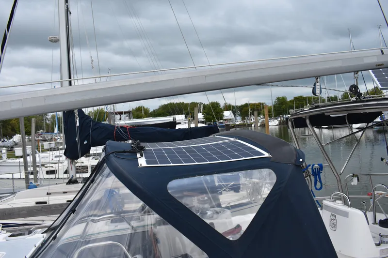 Slide: The Image of Sailboat with solar panel, Hunter 386, 2003 model, docked at marina under cloudy sky. - 12