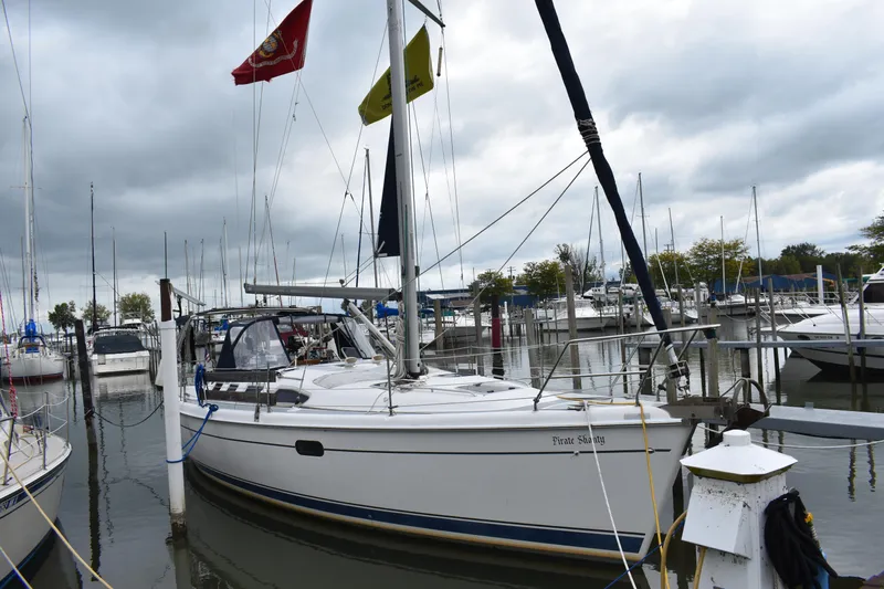 Slide: The Image of 2003 Hunter 386 sailboat docked at a marina under cloudy skies. - 6