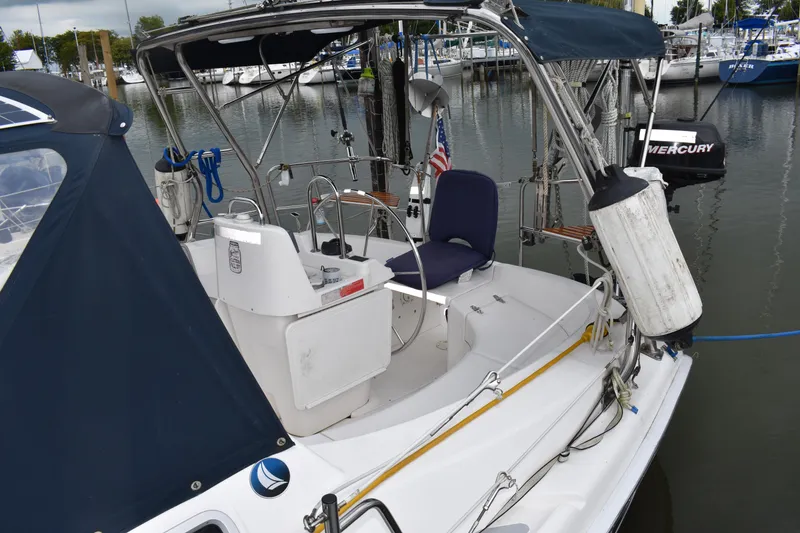 Slide: The Image of 2003 Hunter 386 sailboat docked, featuring cockpit and steering wheel, with marina background. - 13