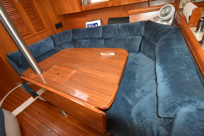 Slide: The Image of Cozy interior of 2003 Hunter 386 sailboat with blue cushioned seating and wooden table. - 37