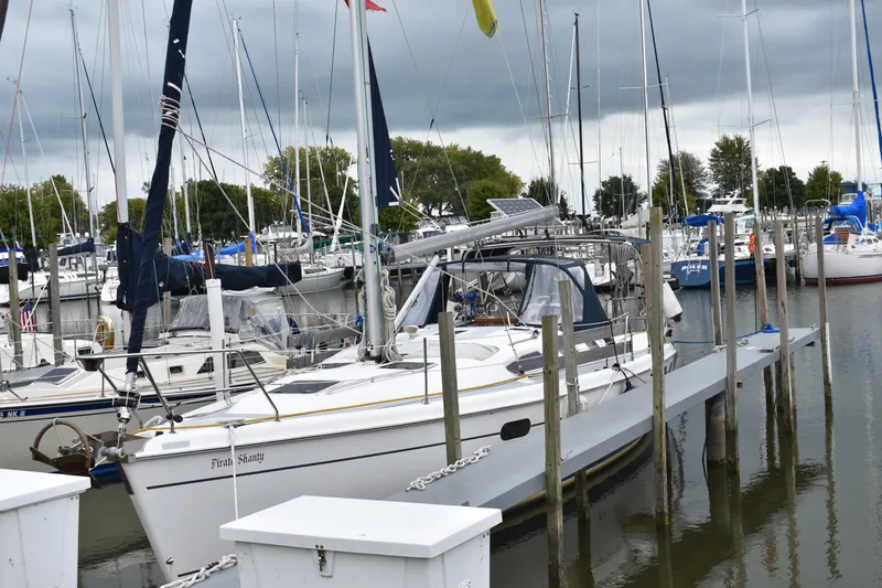 Slide: The Image of 2003 Hunter 386 sailboat docked in a marina under cloudy skies. - 2