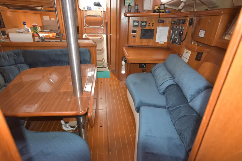 Slide: The Image of Interior of 2003 Hunter 386 sailboat with wooden furnishings and blue seating. - 43