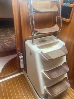 Slide: The Image of Interior stairs of a 2003 Hunter 386 sailboat with wooden steps and a fire extinguisher. - 30