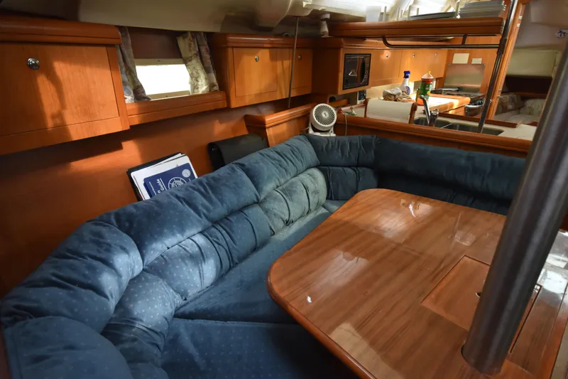 Slide: The Image of Cozy interior of 2003 Hunter 386 sailboat with plush seating and wooden table. - 39