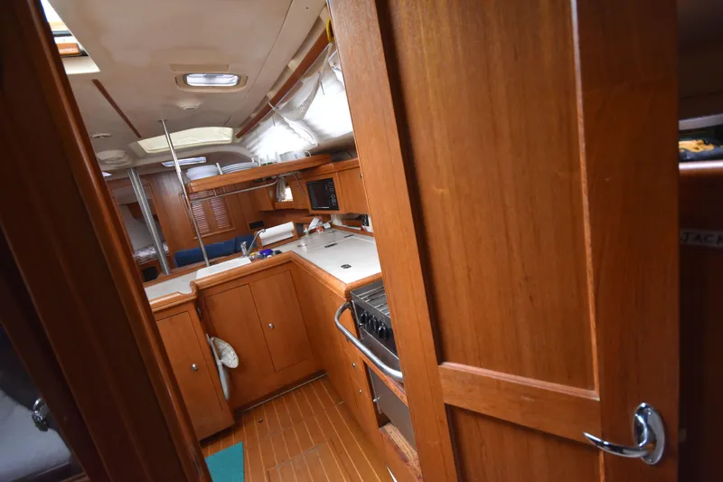 Slide: The Image of Interior of 2003 Hunter 386 sailboat with wooden cabinetry and compact kitchen area. - 45