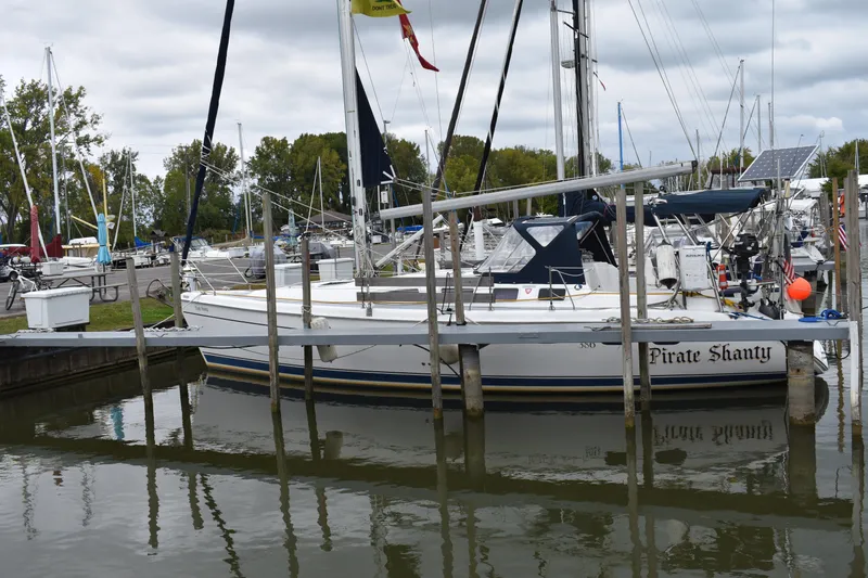 Slide: The Image of 2003 Hunter 386 sailboat docked at marina, named "Pirate Shanty," surrounded by calm water. - 5