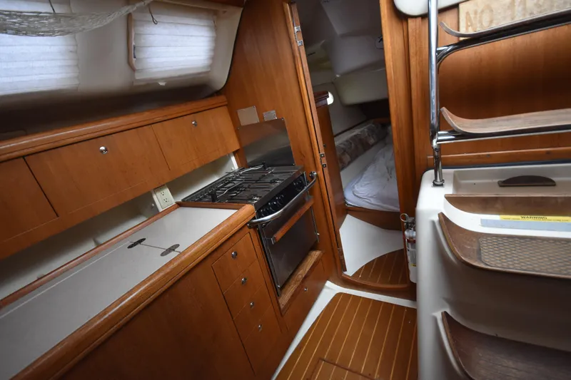 Slide: The Image of Interior of a 2003 Hunter 386 sailboat, featuring a compact kitchen and cozy sleeping area. - 36