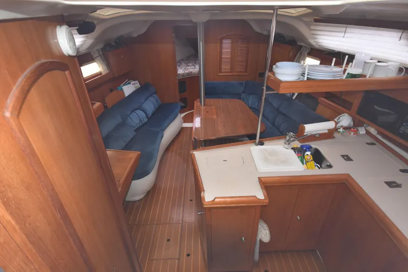 Slide: The Image of Interior of 2003 Hunter 386 sailboat with wooden cabinetry and blue seating. - 29