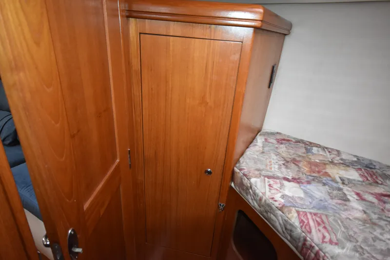 Slide: The Image of Wooden cabin interior of 2003 Hunter 386 sailboat with patterned bedding. - 48
