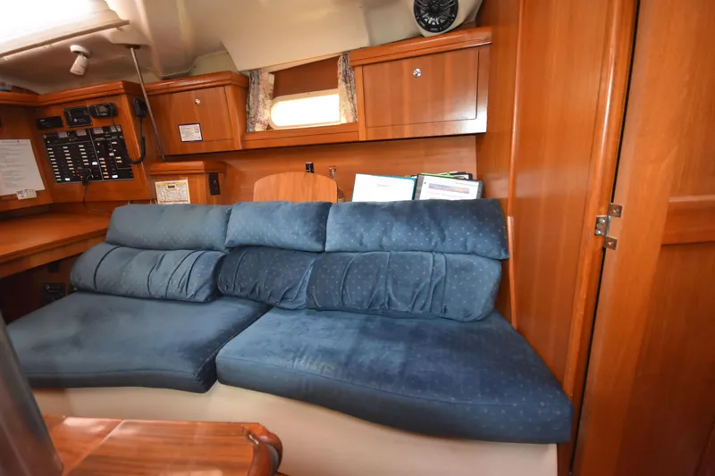 Slide: The Image of Interior of a 2003 Hunter 386 yacht with blue cushioned seating and wooden cabinetry. - 40