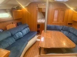 Slide: The Image of Interior of 2003 Hunter 386 sailboat with blue seating and wooden finishes. - 31