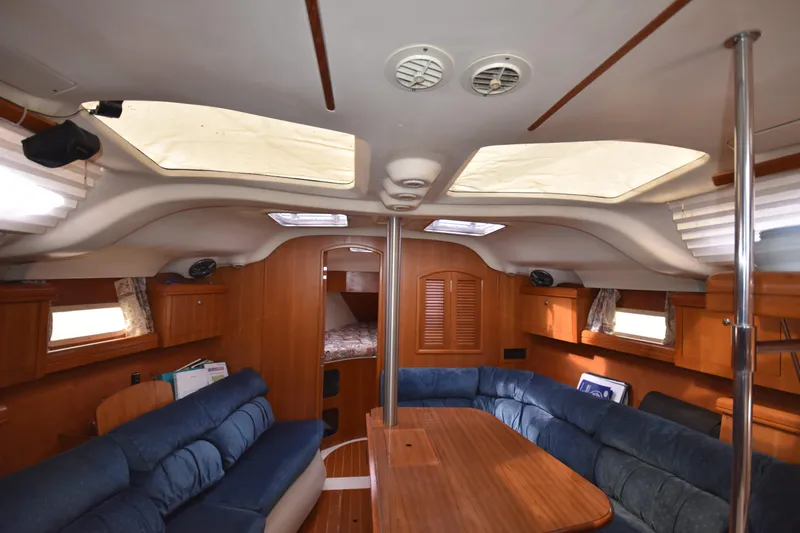 Slide: The Image of Interior of 2003 Hunter 386 sailboat with wooden furnishings and blue seating. - 38