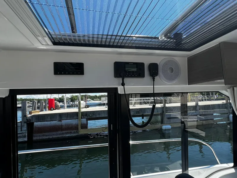 Slide: The Image of Interior view of 2025 Jeanneau NC 895 boat with electronic controls and marina backdrop. - 12