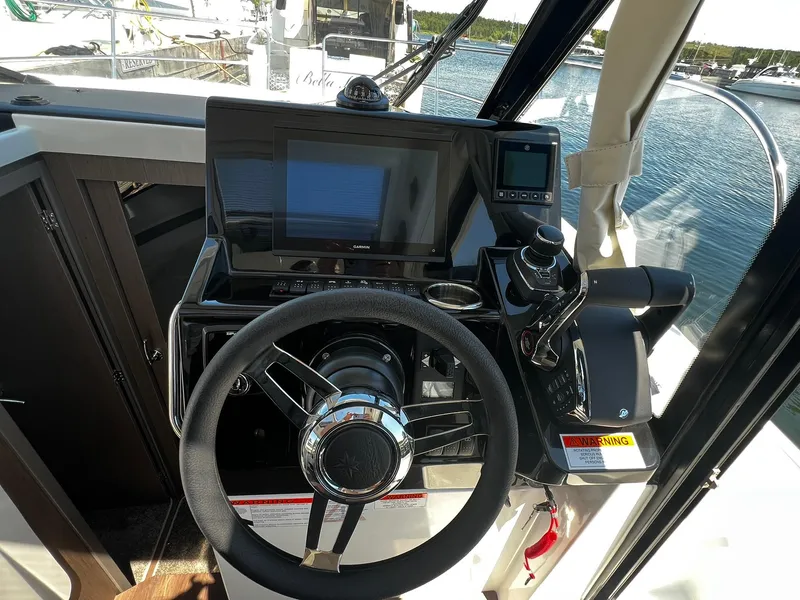 Slide: The Image of Helm of 2025 Jeanneau NC 895 boat with modern navigation equipment and steering wheel. - 16