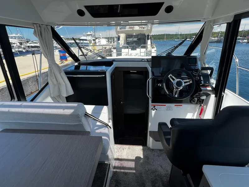 Slide: The Image of Interior view of 2025 Jeanneau NC 895 boat, featuring helm and seating area. - 18
