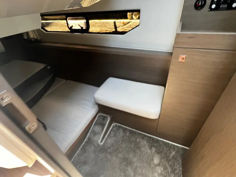 Slide: The Image of 2025 Jeanneau NC 895 cabin interior with bed, window, and seating area. - 20