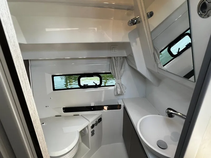 Slide: The Image of 2025 Jeanneau NC 895 boat bathroom with modern fixtures and window view. - 22