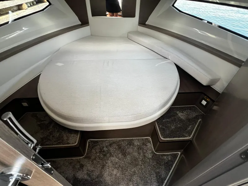 Slide: The Image of 2025 Jeanneau NC 895 cabin interior with round bed and modern design. - 24