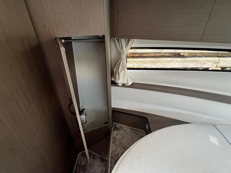 Slide: The Image of 2025 Jeanneau NC 895 interior cabin with window, storage, and seating area. - 26