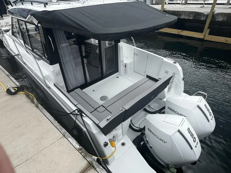 Slide: The Image of 2025 Jeanneau NC 895 boat with twin Mercury outboard engines docked at marina. - 4