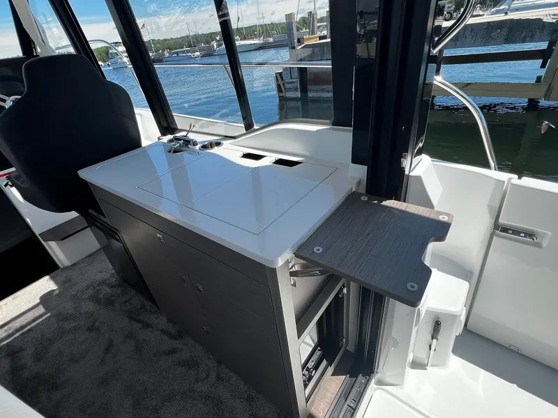 Slide: The Image of Interior of 2025 Jeanneau NC 895 boat with compact kitchen and water view. - 8