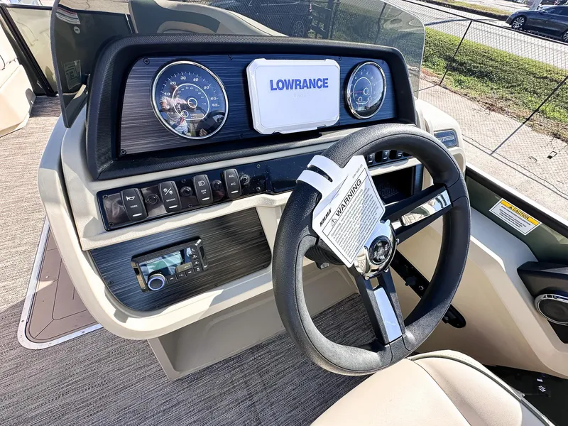 Slide: The Image of Steering console of 2025 Godfrey Sweetwater Tritoon with Lowrance display and gauges. - 11
