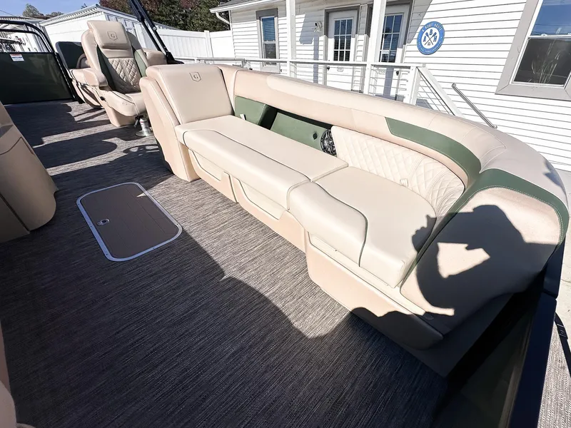 Slide: The Image of 2025 Godfrey Sweetwater Tritoon with beige split bench seating, outdoor setting. - 7