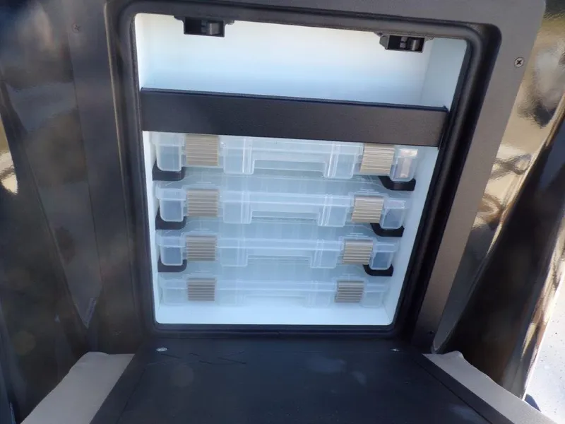 Slide: The Image of Storage compartment of 2025 Xpress H24Bay boat, featuring organized shelves and secure latches. - 11