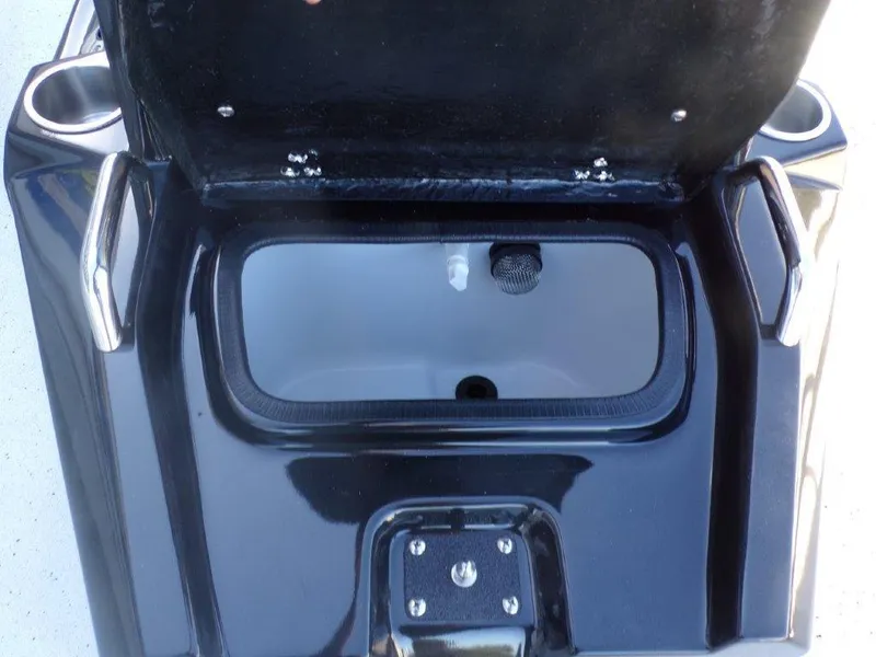 Slide: The Image of 2025 Xpress H24Bay boat storage compartment with open lid and cup holders. - 12