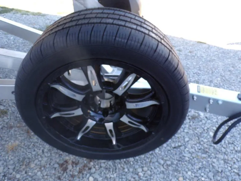 Slide: The Image of 2025 Xpress H24Bay trailer wheel on gravel surface. - 20