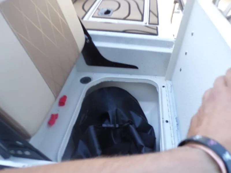 Slide: The Image of Interior view of 2025 Xpress H24Bay boat storage compartment with seat and black cover. - 6