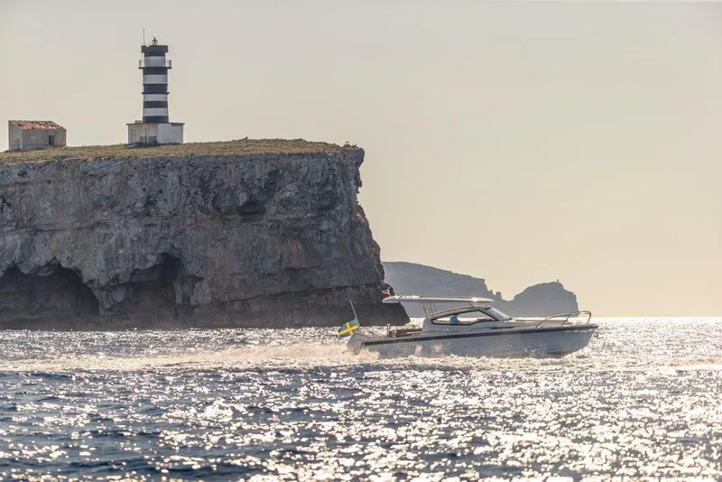 Slide: The Image of Nimbus W9 boat cruising near rocky cliff with lighthouse, 2024 model. - 14
