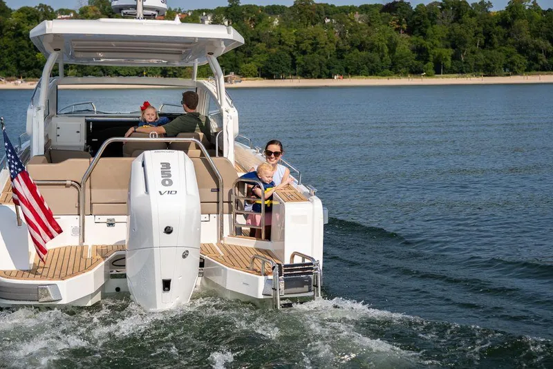 Slide: The Image of Family enjoying a ride on a 2024 Nimbus W9 boat in a scenic lake. - 18
