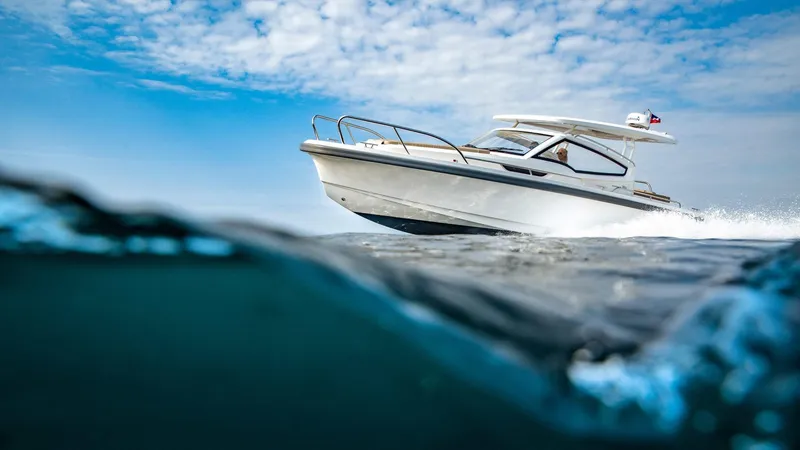 Slide: The Image of 2024 Nimbus W9 boat cruising on open water under a cloudy sky. - 3