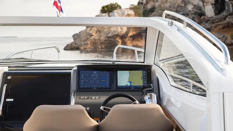 Slide: The Image of 2024 Nimbus W9 boat cockpit with navigation screens, steering wheel, and scenic ocean view. - 4