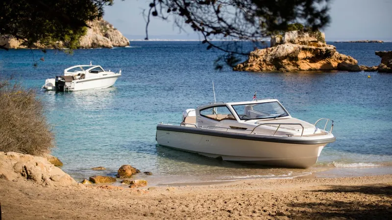 Slide: The Image of 2024 Nimbus W9 boat on a scenic beach with clear blue water. - 5