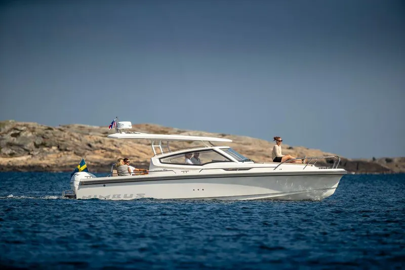 Slide: The Image of 2024 Nimbus W9 boat cruising on blue water near rocky shoreline. - 6