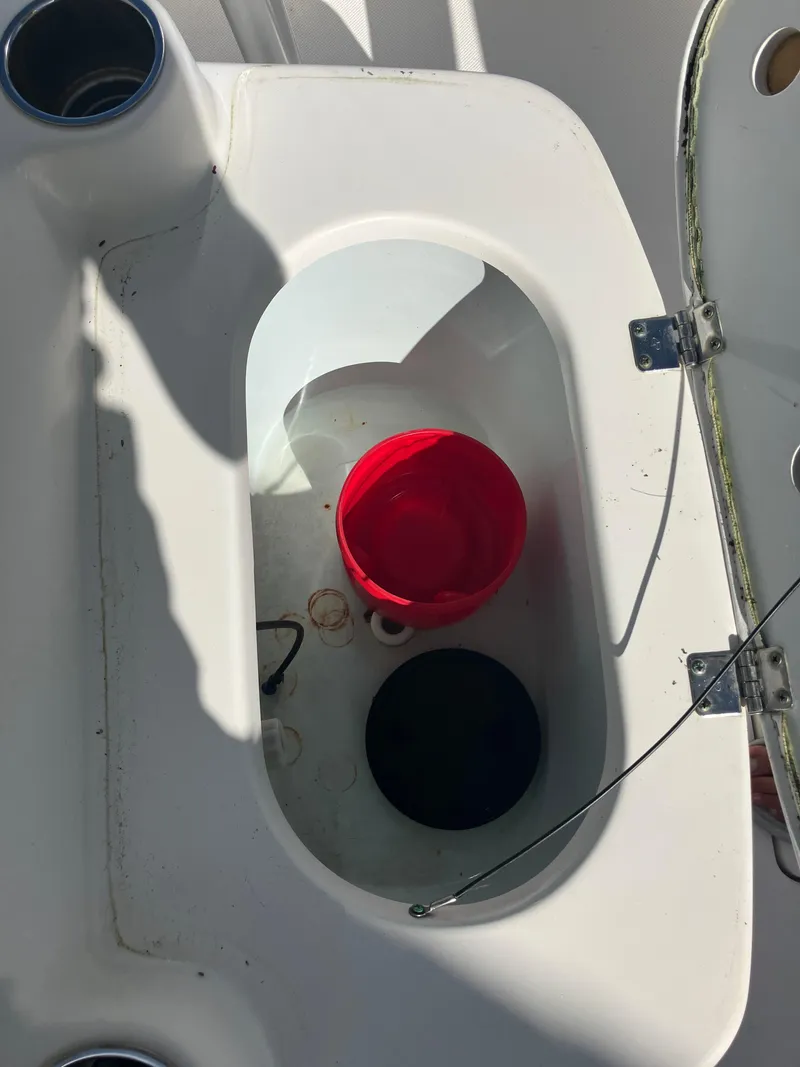 Slide: The Image of 2015 Sea Born FX24 Bay boat storage compartment with red and black buckets. - 11