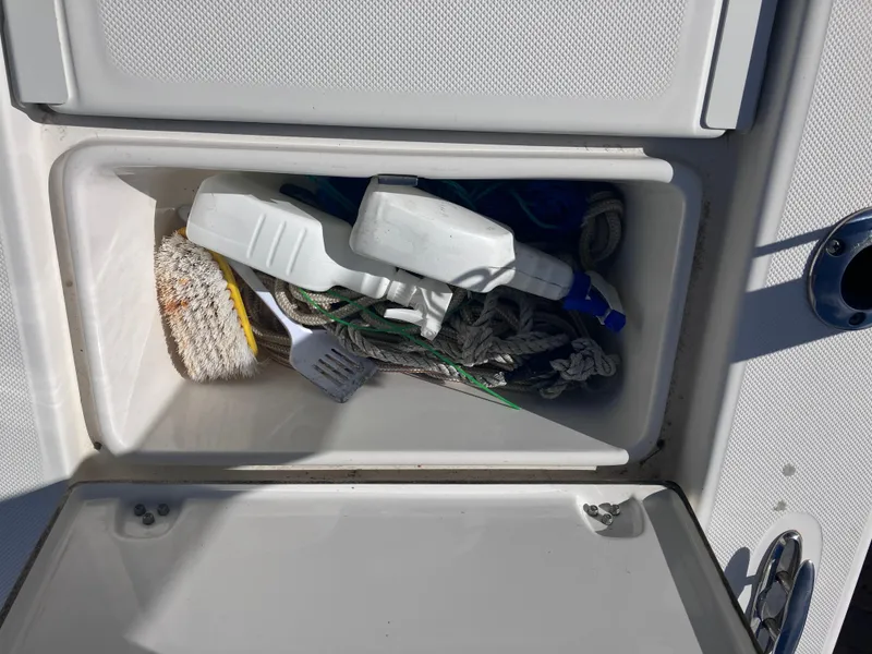 Slide: The Image of Storage compartment on 2015 Sea Born FX24 Bay boat with cleaning supplies and rope. - 16