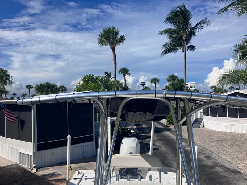 Slide: The Image of 2015 Sea Born FX24 Bay boat with T-top, parked near palm trees under a blue sky. - 26