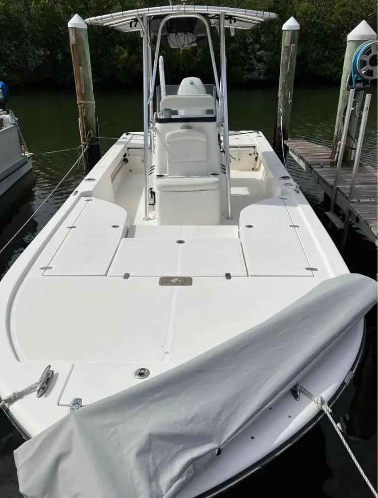 Slide: The Image of 2015 Sea Born FX24 Bay boat docked, featuring a spacious deck and T-top. - 3
