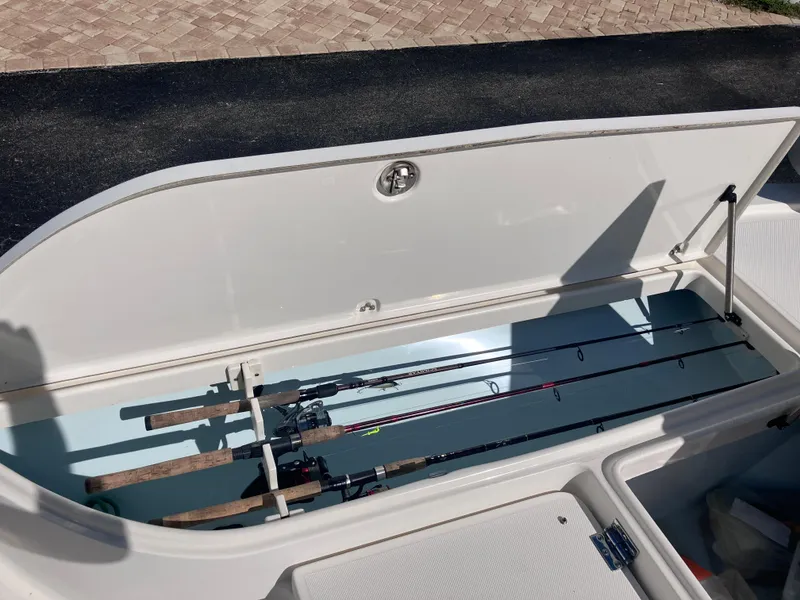 Slide: The Image of 2015 Sea Born FX24 Bay boat with open storage compartment holding fishing rods. - 31